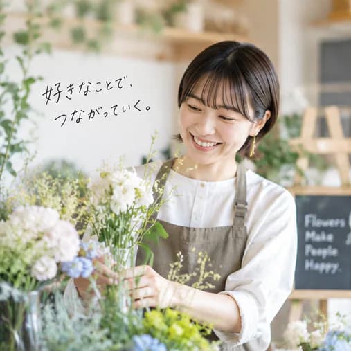 花屋の店先で花束を束ねながら笑う人。「好きなことで、つながっていく。」